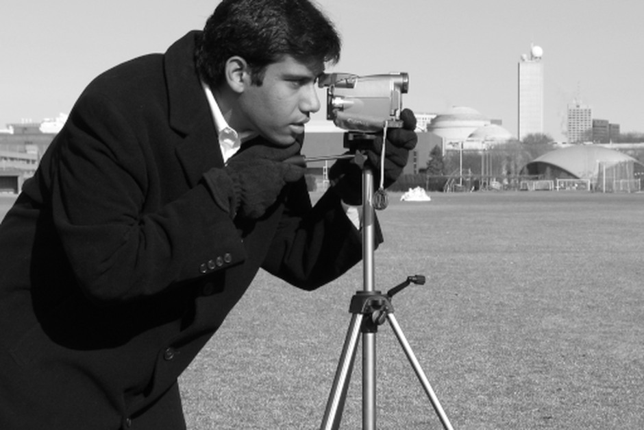 A photographer working carefully with a camera and tripod, representing observation and precision.